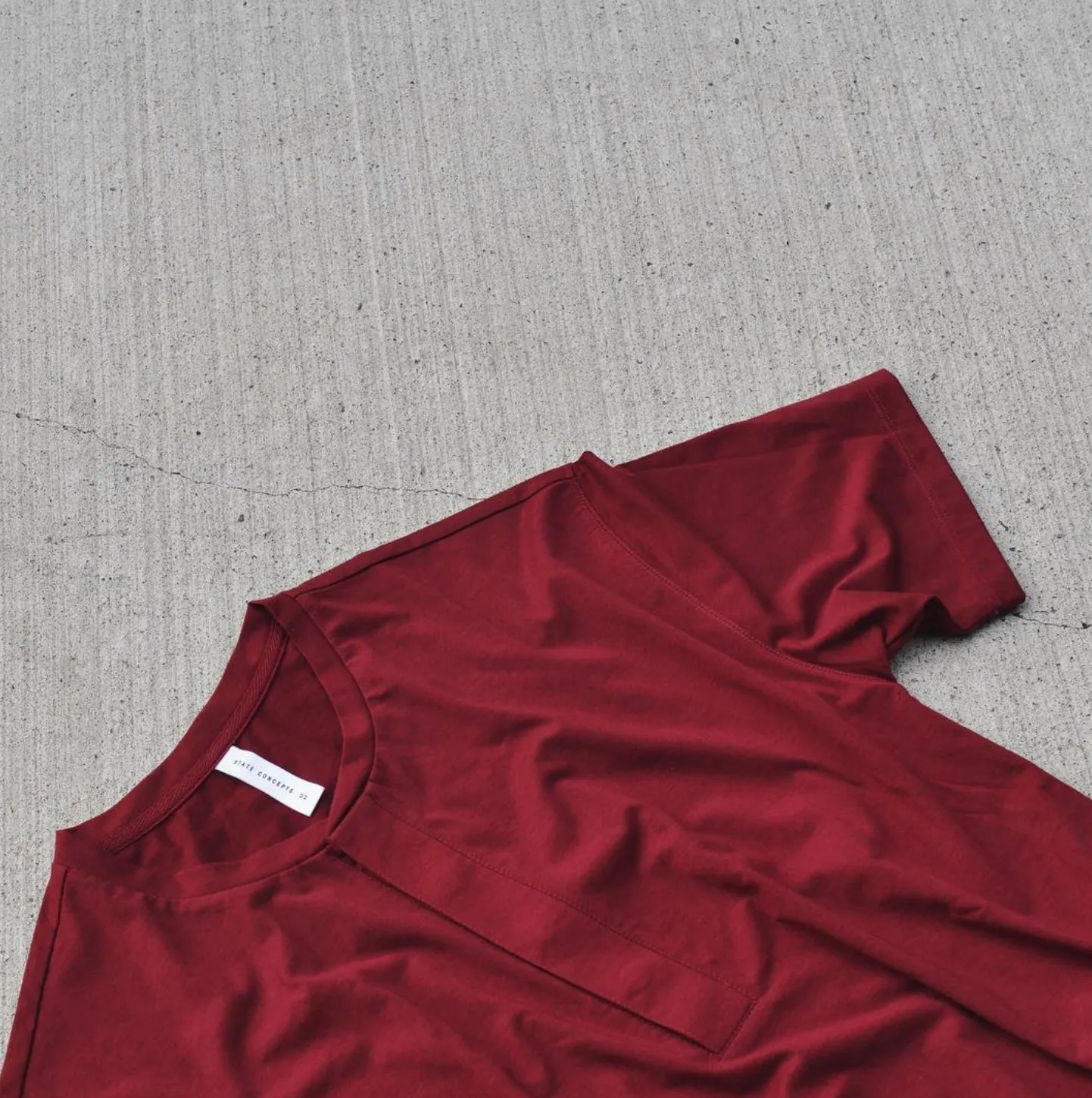 State Concepts — burgundy tee on concrete